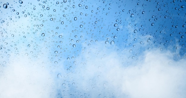 Gotas de chuva na janela de vidro azul com fundo de neblina