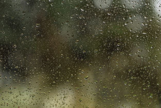 Gotas de chuva na janela de vidro como plano de fundo.