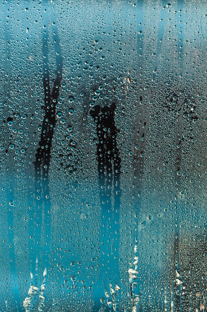 Gotas de chuva no fundo abstrato azul da janela