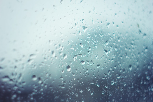 Gotas de chuva no vidro com tonalidade azul