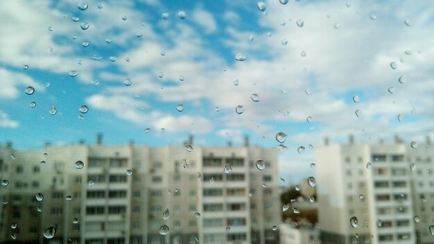 Foto gotas de chuva no vidro contra os edifícios