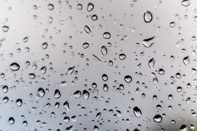 Gotas de chuva no vidro da janela do lado de fora da textura da água do fundo maravilhoso