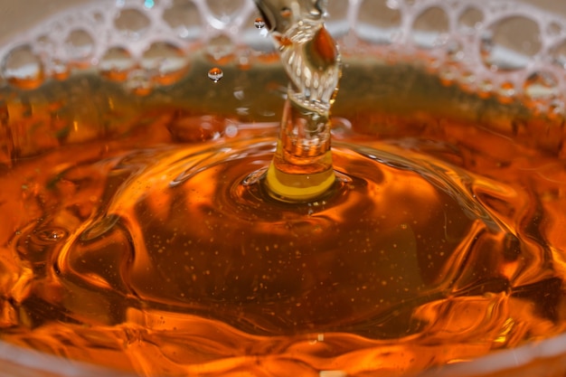 Gotas e bolhas de cerveja light em um tiro de bala de vidro macro fotografia