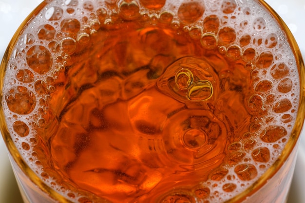Gotas e bolhas de cerveja light em um tiro de bala de vidro macro fotografia
