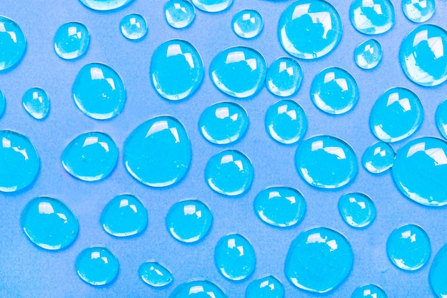 Gotas de gel azul formando un fondo El concepto de protección contra virus o cosméticos El telón de fondo perfecto para una presentación