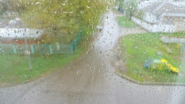 Las gotas de lluvia caen sobre una ventana fuertemente empañada y fluyen hacia abajo