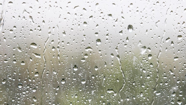 Gotas de lluvia y gotas de lluvia en el cristal de la ventana