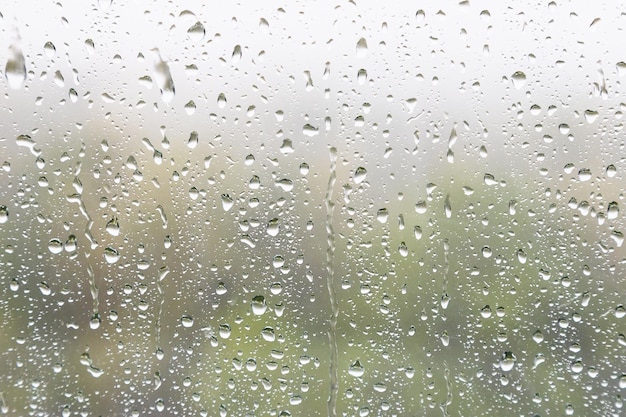 Gotas de lluvia y gotas de lluvia en el cristal de la ventana