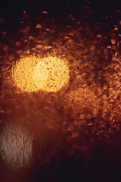 Gotas de lluvia y luces borrosas a través de una ventana.