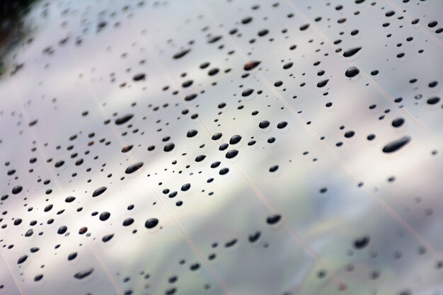 Las gotas de lluvia salpican el cristal de la ventana del coche.