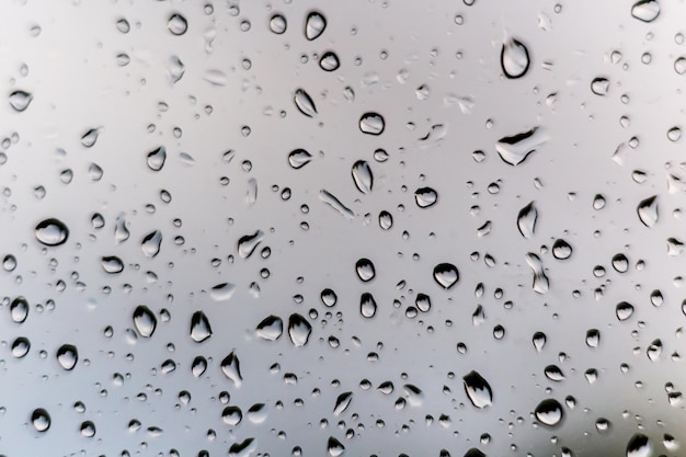 Gotas de lluvia sobre el cristal de la ventana exterior de textura de agua de fondo maravilloso