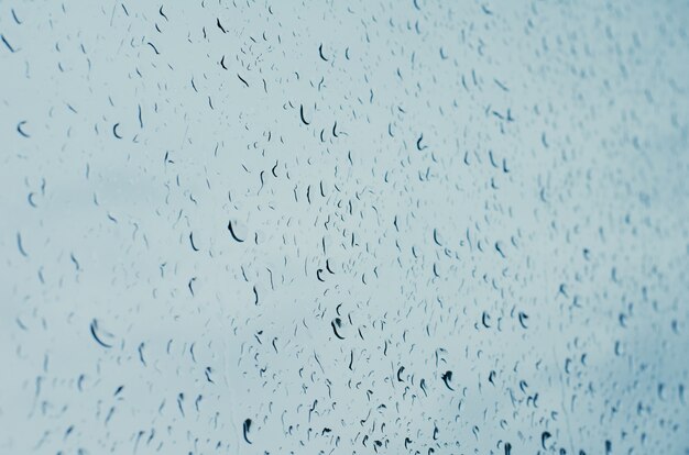 Gotas de lluvia sobre el cristal de la ventana, tonos azules, fondo