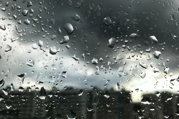 Gotas de lluvia sobre el vidrio para los fondos del clima lluvioso del otoño