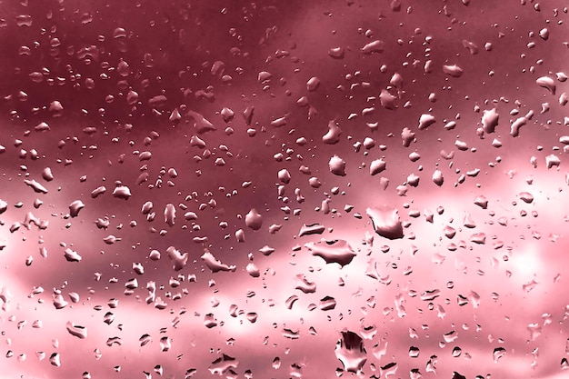 Gotas de lluvia sobre el vidrio para el telón de fondo rojo lluvioso clima de otoño Fondos abstractos con gotas de lluvia en la ventana