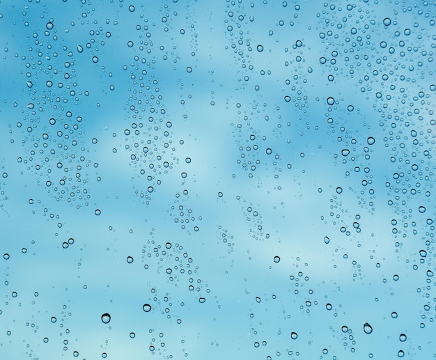 Gotas de lluvia en la ventana de un barco en el mar con nubes