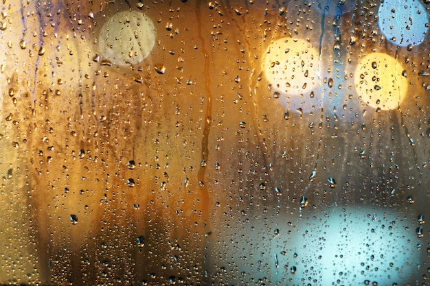 Gotas de lluvia en la ventana de cristal con fondo bokeh