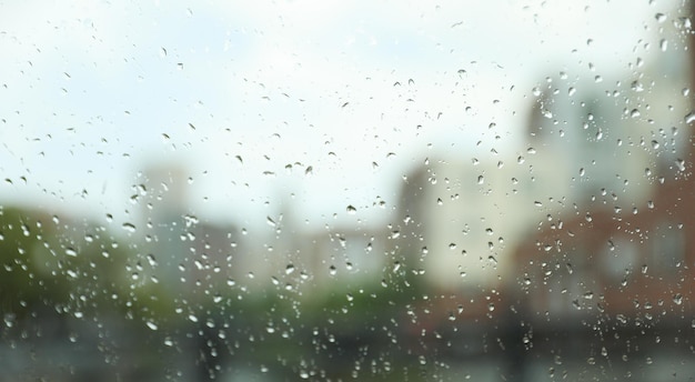 Gotas de lluvia en una ventana con un edificio al fondo.