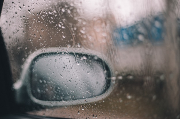 Gotas de lluvia en la ventana de un espejo de coche