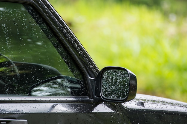 Gotas de lluvia en la ventana y el espejo lateral del vidrio del coche