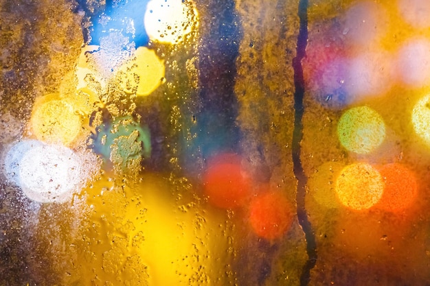 Gotas de lluvia en la ventana con fondo amarillo brillante