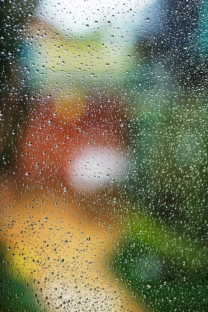 Gotas de lluvia en la ventana con luces abstractas bokeh.