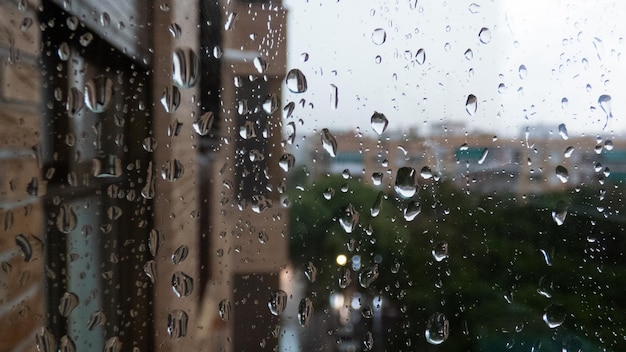 Gotas de lluvia en la ventana que mira la ciudad