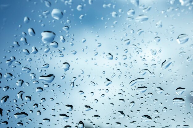 Foto gotas de lluvia en el vidrio cielo azul y clima sombrío hermoso fondo del cielo