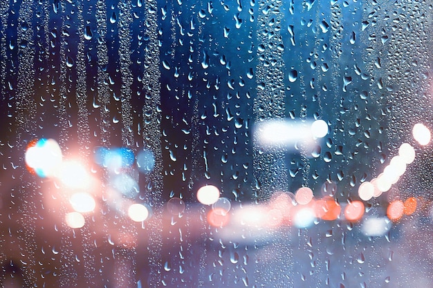 gotas na estrada de vidro chuva noite de outono / fundo abstrato de outono na cidade, tráfego de automóveis, viagem romântica de carro