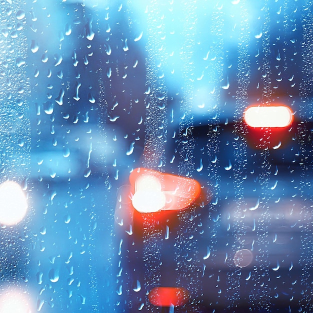 gotas no vidro auto estrada chuva noite de outono / fundo abstrato de outono na cidade, tráfego de automóveis, viagem romântica de carro