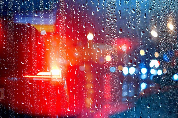 gotas no vidro auto estrada chuva noite de outono / fundo abstrato de outono na cidade, tráfego de automóveis, viagem romântica de carro