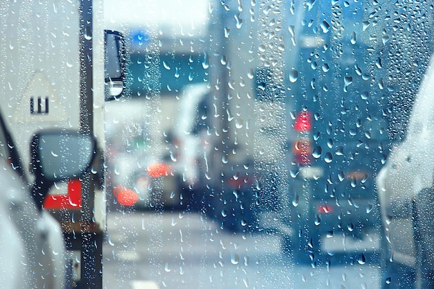 Gotas sobre vidrio auto carretera lluvia noche de otoño / fondo abstracto de otoño en la ciudad, tráfico de automóviles, viaje romántico en coche