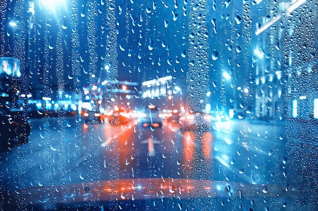 Gotas sobre vidrio auto carretera lluvia noche de otoño / fondo abstracto de otoño en la ciudad, tráfico de automóviles, viaje romántico en coche