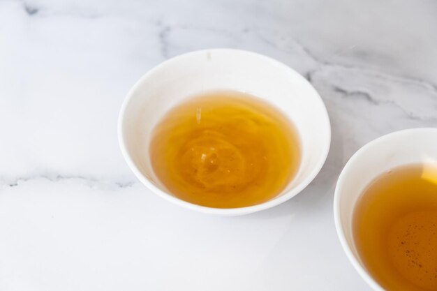 Las gotas de té caen en una taza Concepto de ceremonia del té