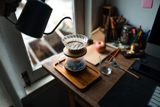 Goteja café em casa, despejando água quente sobre um gotejamento de café