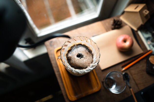 Goteja café em casa, despejando água quente sobre um gotejamento de café