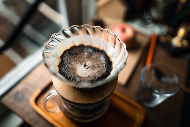 Goteo de café en casa, vertiendo agua caliente sobre un goteo de café