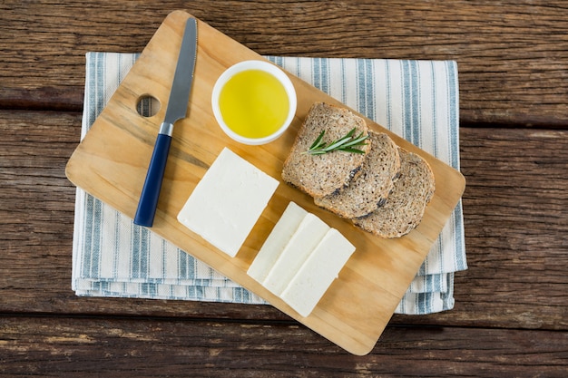 Gouda, Schwarzbrotscheiben und Limettensaft mit Messer auf Schneidebrett