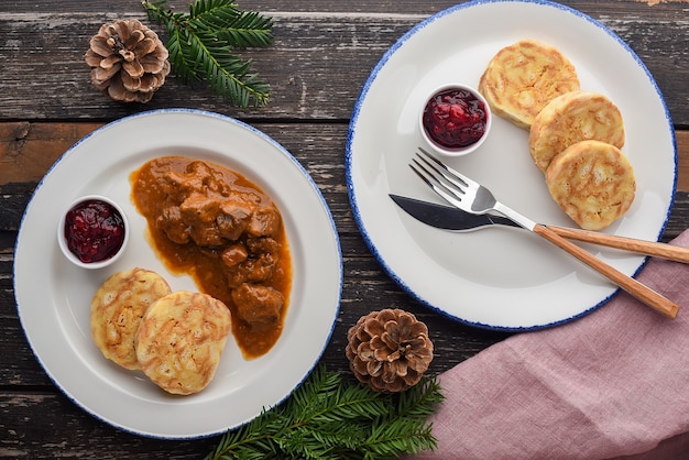 Foto goulash de cervo com bolinhos e geléia de cranberry