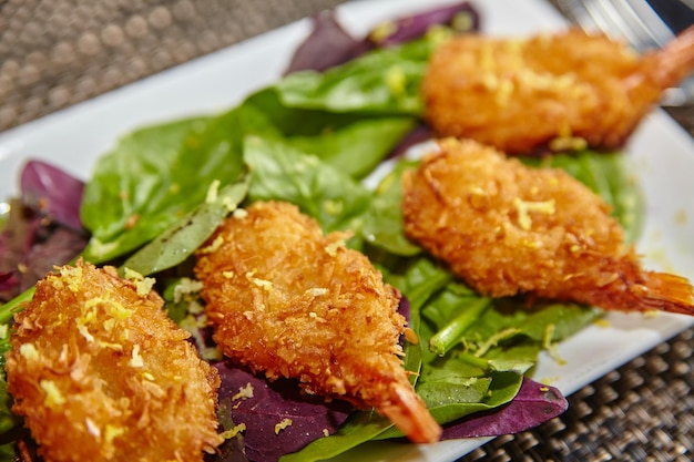 Gourmet-Crispy-Garnelen-Salat auf lebendigem Grün aus der Nähe