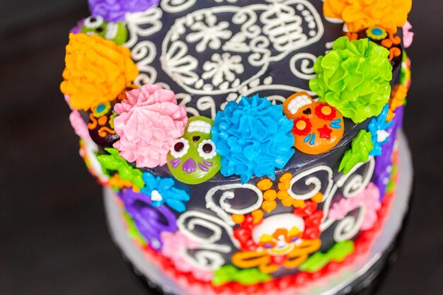 Gourmet-Dia de los Muertos-Torte, verziert mit buntem Buttercreme-Zuckerguss und gummiartigen Cupcake-Toppern.