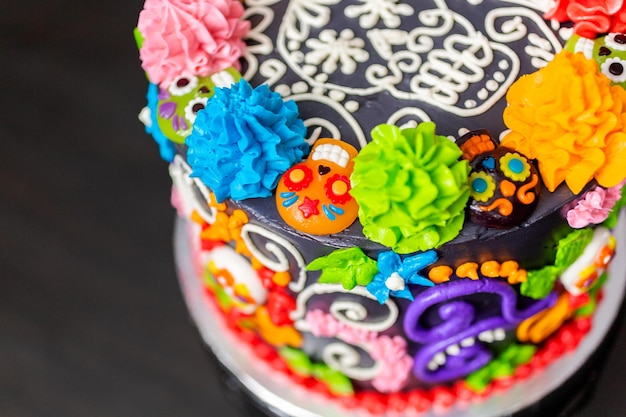 Gourmet-Dia de los Muertos-Torte, verziert mit buntem Buttercreme-Zuckerguss und gummiartigen Cupcake-Toppern.