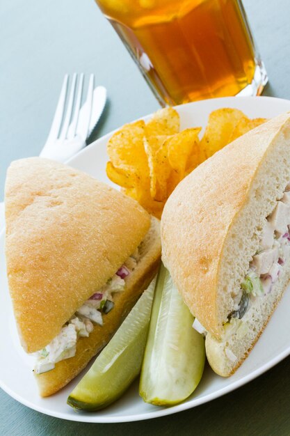 Gourmet-Hühnersalat-Sandwich mit Pommes Frites an der Seite.