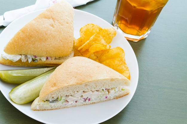 Gourmet-Hühnersalat-Sandwich mit Pommes Frites an der Seite.