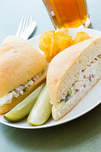 Gourmet-Hühnersalat-Sandwich mit Pommes Frites an der Seite.