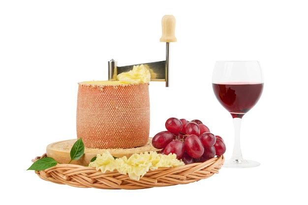 Gourmet leckerer Käse Tete de Moine, ein Glas Rotwein und eine Weintraube isoliert auf weißer Oberfläche