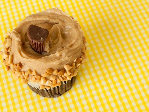 Gourmet Reese's butter cupcake cupcake em fundo amarelo.