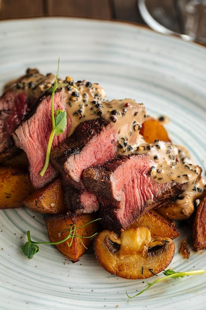 Foto gourmet-rindfleischmedaillons mit kartoffeln und champignons