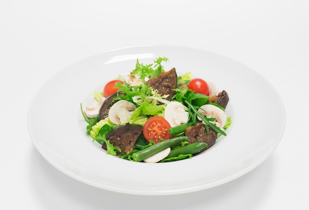 Gourmet-Salat mit Auberginen, Kirschtomaten, grünen Bohnen und Champignons. Draufsicht. Weißer Hintergrund. Gesundes Esskonzept. Gemischte Medien