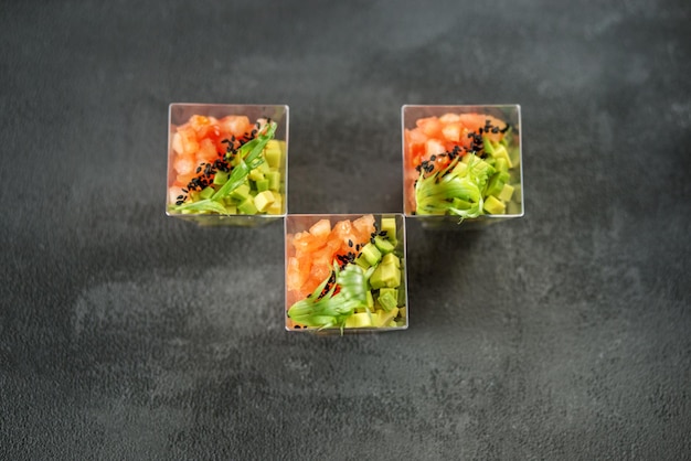 Gourmet-Salat mit Avocado und Tomaten in kleinen Tassen Konzept für Ernährung und gesunde Ernährung