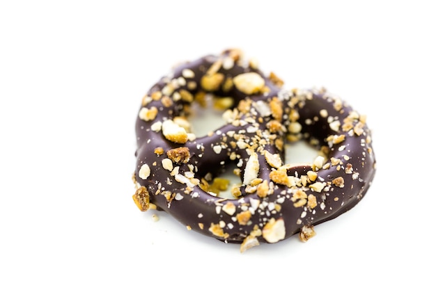 Gourmet-Schokolade überzogene Brezel mit kandierten Erdnüssen auf weißem Hintergrund.